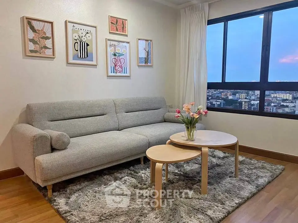 Stylish living room with cozy sofa and city view, perfect for relaxation.