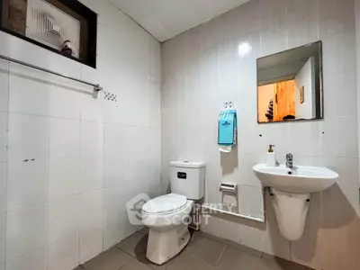 Modern bathroom with sleek fixtures and minimalist design, featuring a wall-mounted sink and toilet.
