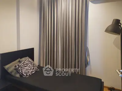 Cozy bedroom with stylish zebra print pillow and elegant curtains