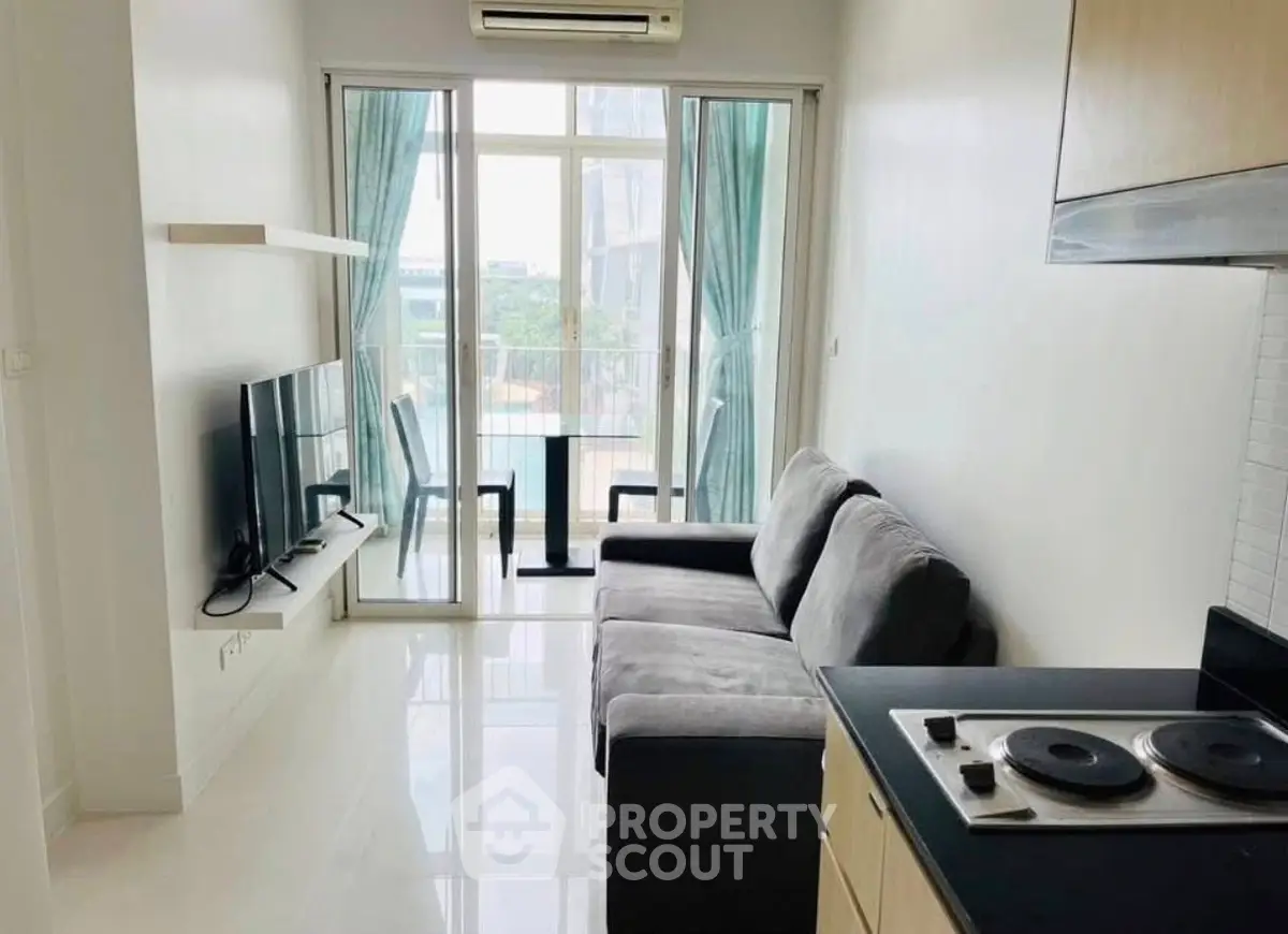 Modern living room with balcony view and sleek kitchen area