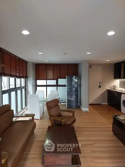 Spacious living room with modern furniture and large windows in a stylish apartment.