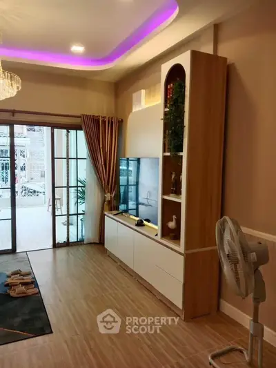 Modern living room with stylish decor and sliding glass doors leading to a balcony.