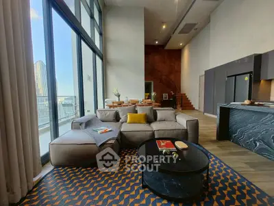 Luxurious modern living room with high ceilings and large windows offering stunning city views.