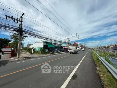 Scenic roadside view with commercial buildings and clear blue sky, ideal for business opportunities.
