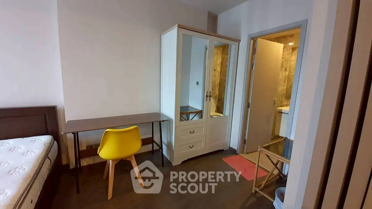 Modern bedroom with study area and ensuite bathroom in a stylish apartment.