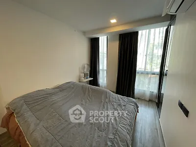 Cozy bedroom with large window and modern decor in urban apartment