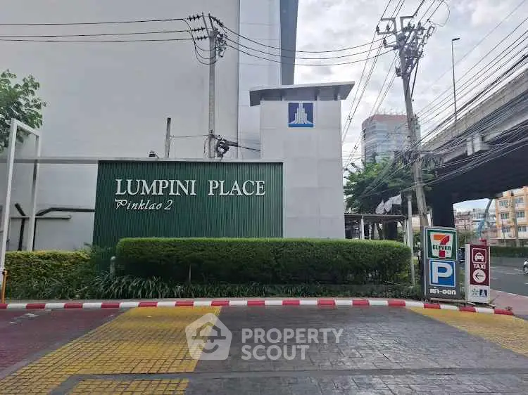 Modern Lumpini Place Pinklao 2 entrance with lush greenery and urban surroundings.