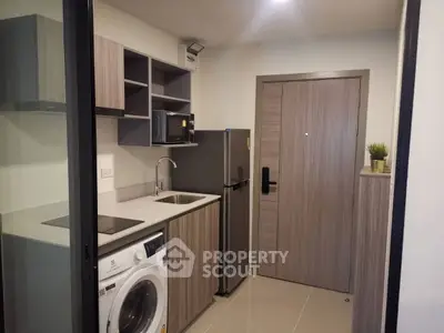 Modern compact kitchen with washing machine and fridge in stylish apartment