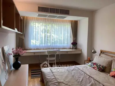 Cozy bedroom with large window, stylish decor, and natural light, perfect for relaxation and comfort.