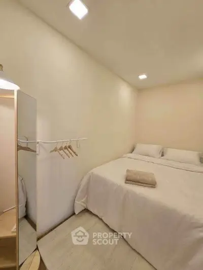 Cozy minimalist bedroom with soft lighting and simple decor, perfect for relaxation.