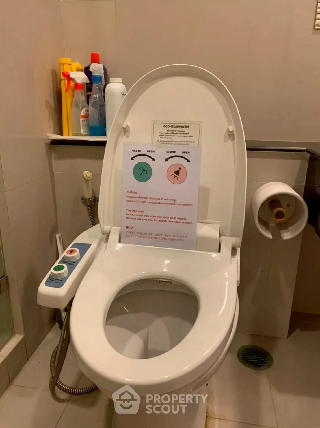 Modern bathroom with smart toilet and cleaning supplies