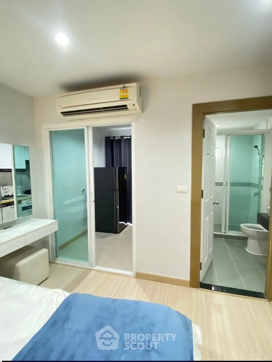Modern bedroom with ensuite bathroom and air conditioning in a stylish apartment.