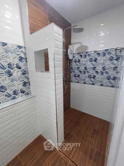 Modern bathroom with stylish tile design and spacious shower area.