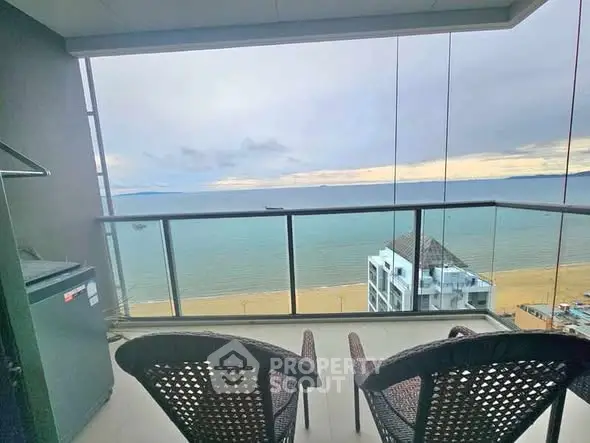 Stunning ocean view from a modern balcony with cozy seating.