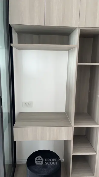 Modern built-in wooden storage unit with shelves and seating in a stylish interior space.