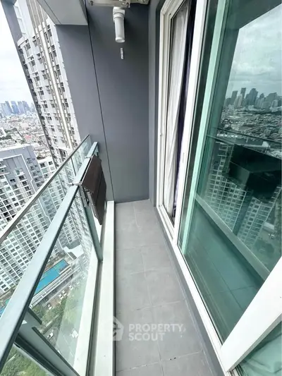 Modern high-rise balcony with city view and glass railing, perfect for urban living.