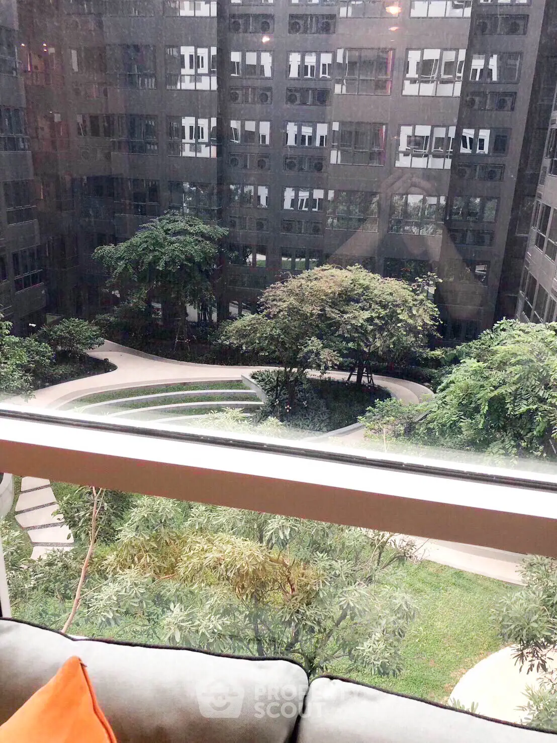 Stunning view of lush garden courtyard from modern apartment window.