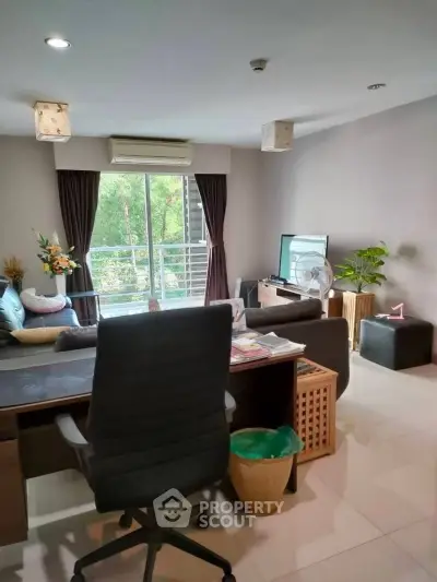 Modern living room with balcony view, stylish furniture, and natural light.