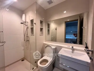 Modern bathroom with glass shower and sleek fixtures in a contemporary home.