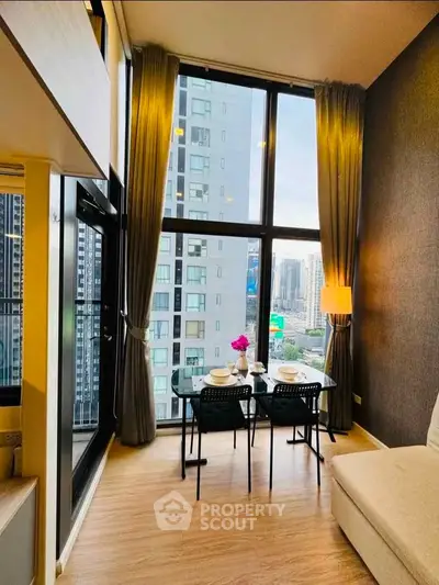 Modern high-rise apartment with floor-to-ceiling windows and city view, featuring a cozy dining area.