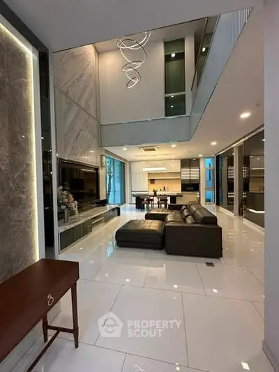 Luxurious modern living room with high ceilings and open kitchen layout, featuring sleek design and elegant lighting.