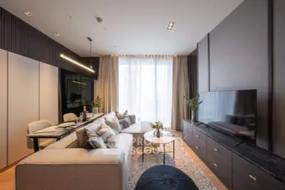 Modern living room with elegant decor, large TV, and cozy seating area in a stylish apartment.