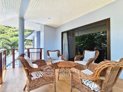 Charming balcony with wicker furniture and lush greenery view, perfect for relaxation and outdoor gatherings.