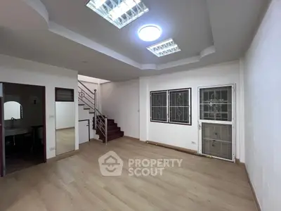Spacious modern living room with wooden flooring and stylish ceiling lights