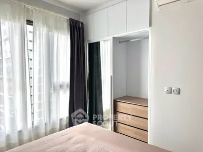 Modern bedroom with natural light and built-in storage in urban apartment.