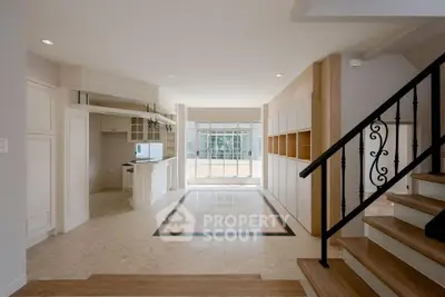 Spacious open-plan living area with elegant staircase and natural light