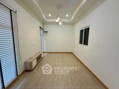 Spacious unfurnished room with modern lighting and large windows, perfect for customization.