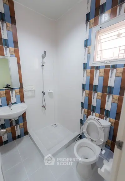 Modern bathroom with unique tile design and compact layout