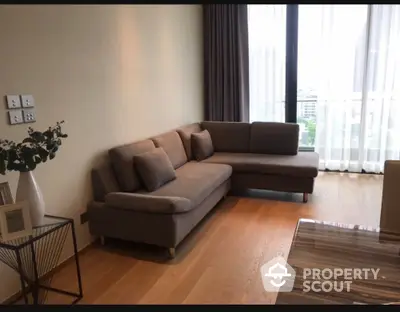 Modern living room with stylish L-shaped sofa and large window view.