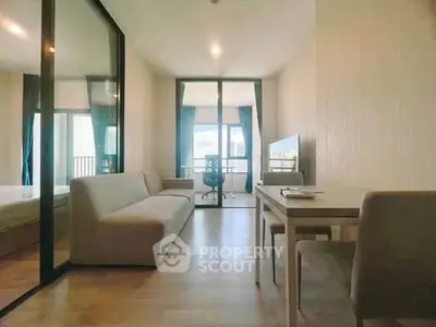 Modern living room with sleek furniture and large windows offering natural light and a view.