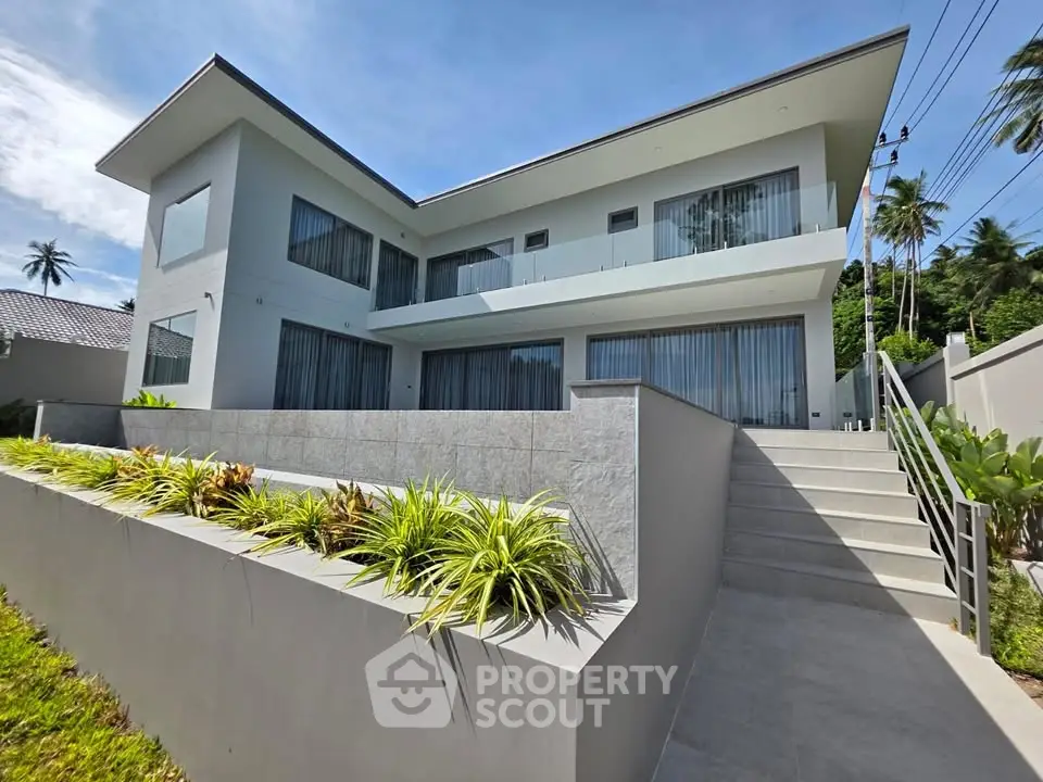 Modern two-story house with sleek design and lush landscaping