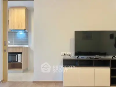 Modern living room with TV and view into stylish kitchen