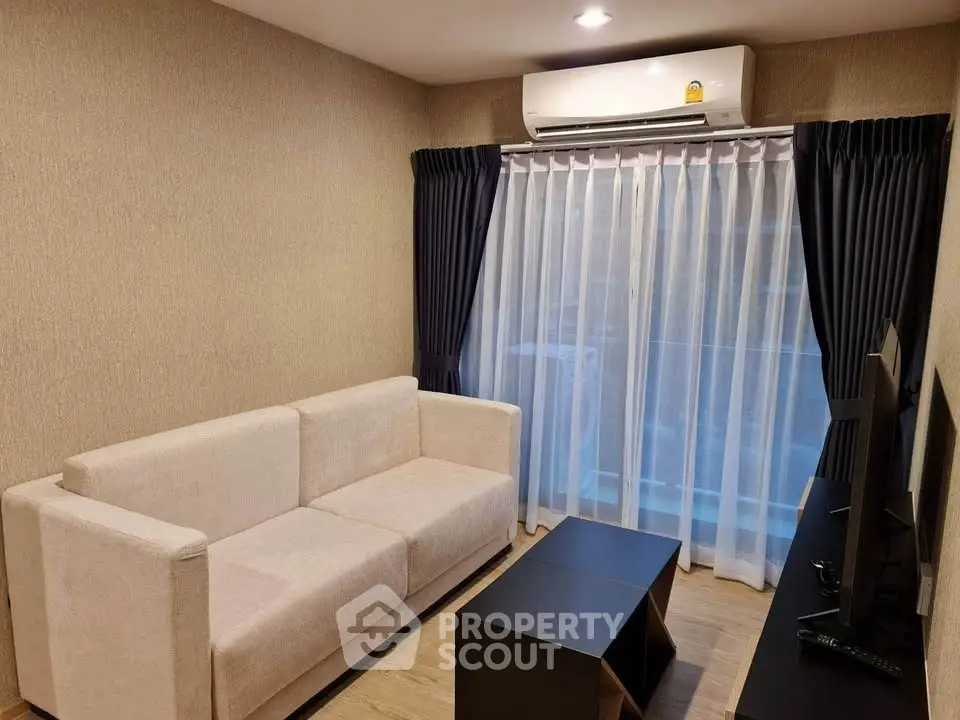 Cozy living room with modern sofa and TV, featuring elegant curtains and air conditioning.