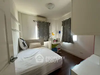 Cozy bedroom with modern decor and ample natural light, perfect for restful nights.