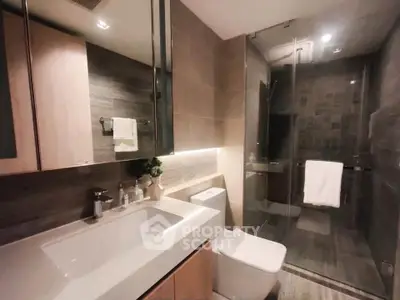 Modern bathroom with sleek design, glass shower, and elegant fixtures.