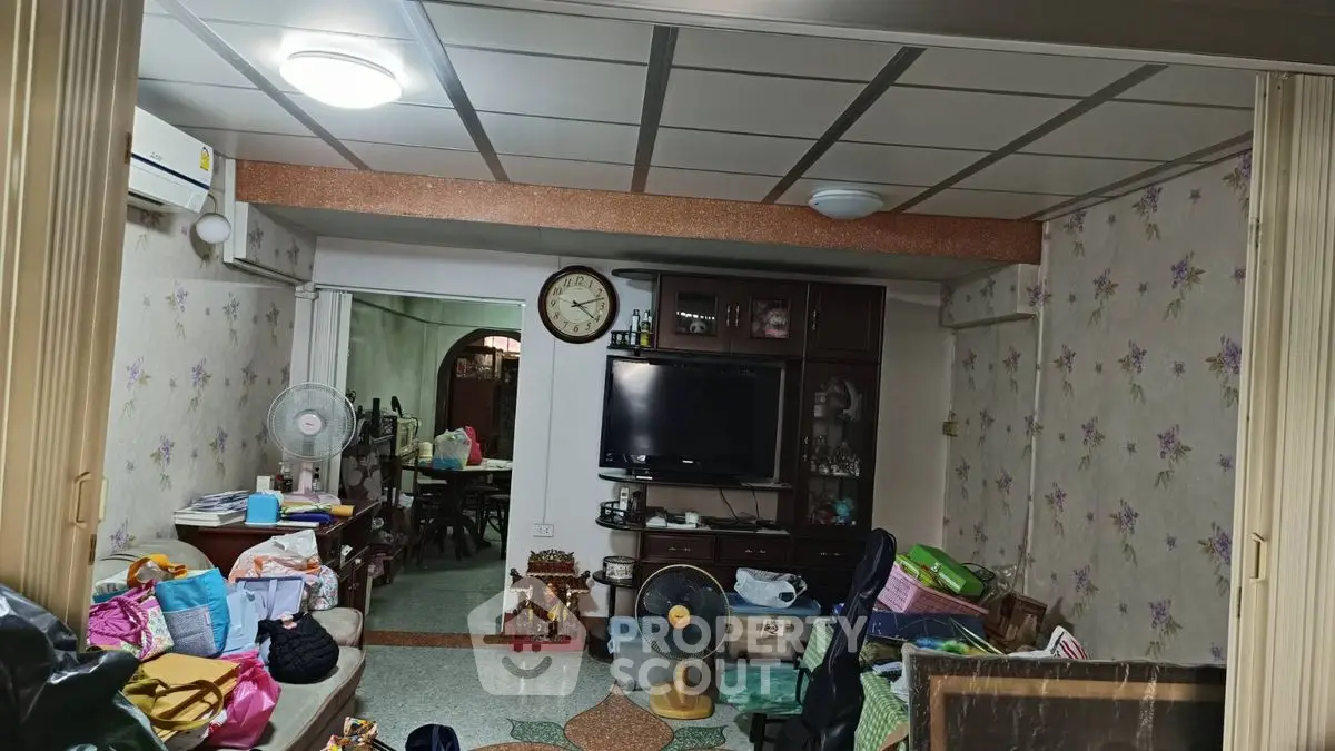 Spacious living room with floral wallpaper and modern amenities, ideal for family gatherings.