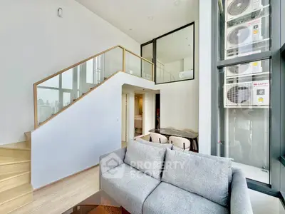 Modern duplex living room with high ceilings and stylish staircase