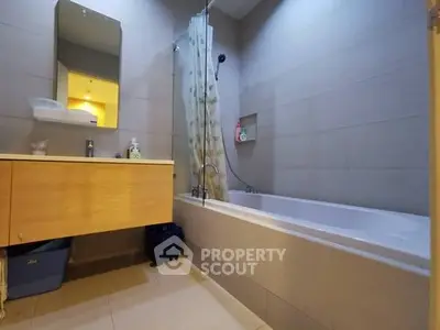 Modern bathroom with bathtub and sleek vanity in a contemporary home.