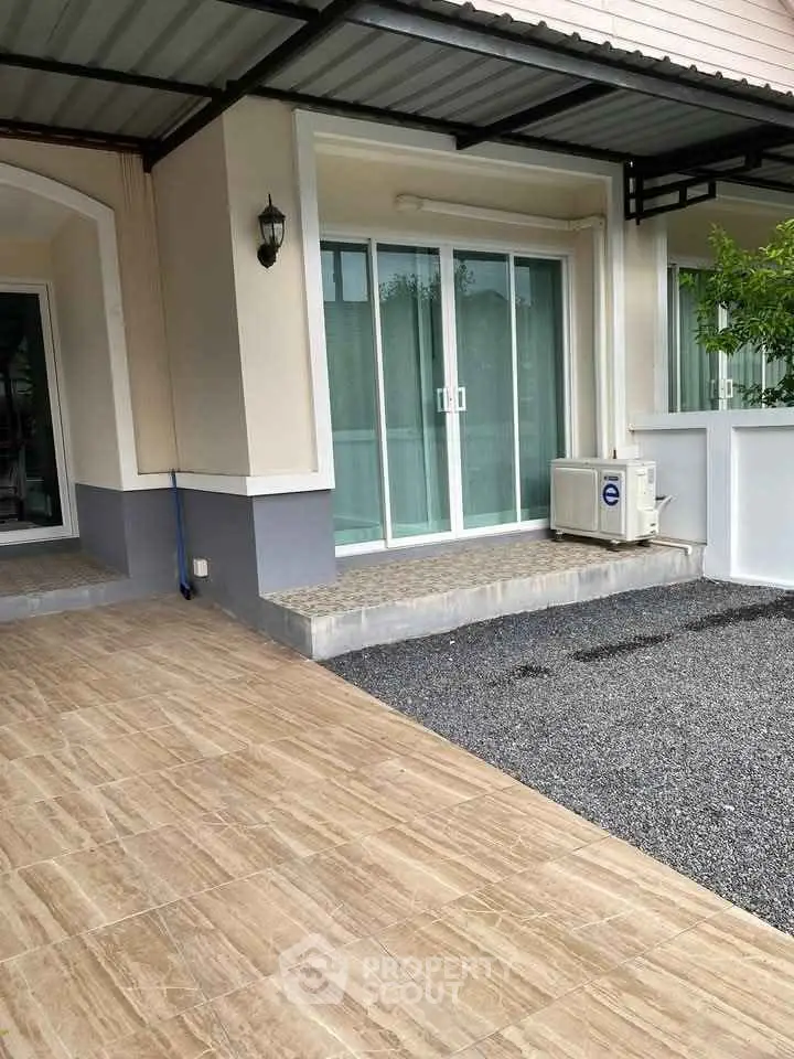 Modern home exterior with sliding glass doors and covered patio area.