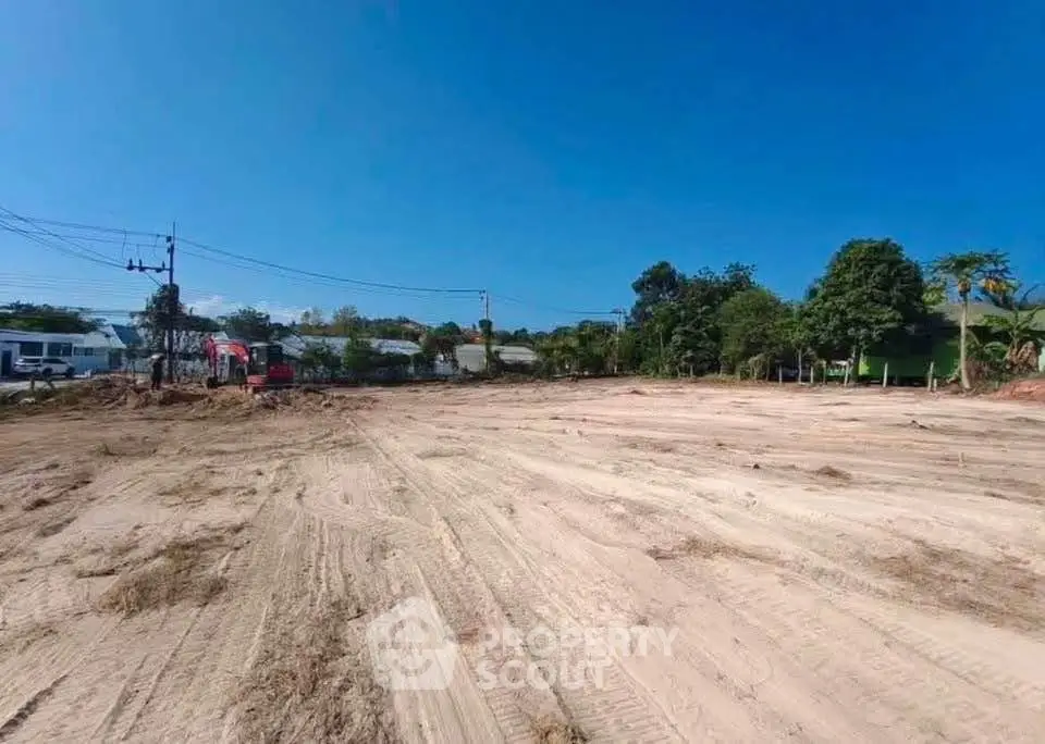 Expansive vacant land with clear blue sky, ideal for development opportunities.