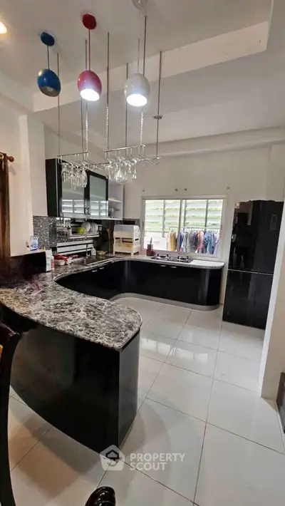 Modern kitchen with sleek black cabinetry and stylish pendant lighting