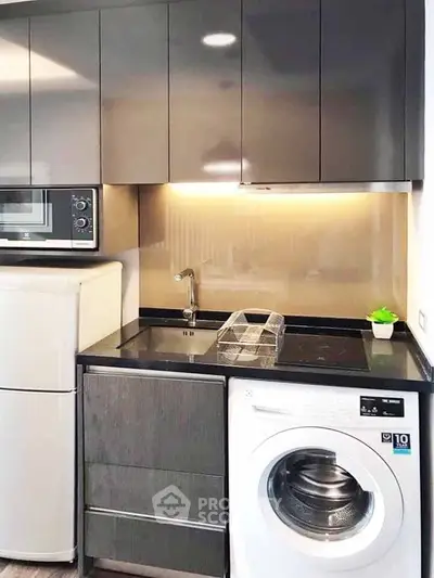 Modern kitchen with sleek cabinets, washing machine, and built-in microwave for efficient living.