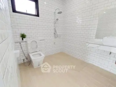 Spacious modern bathroom with white subway tiles and wooden flooring