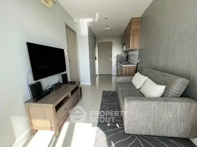 Modern living room with sleek furniture and wall-mounted TV in a cozy apartment.