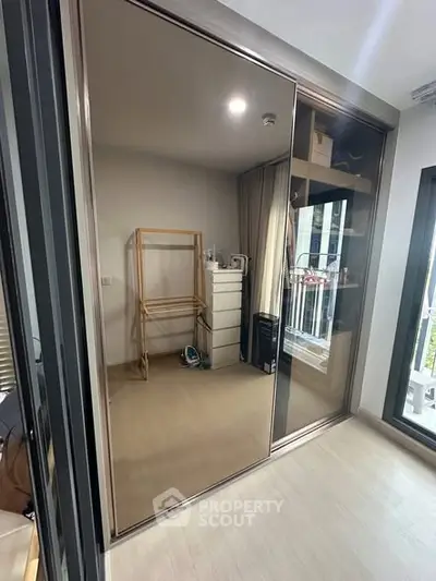 Modern bedroom with mirrored wardrobe and balcony view