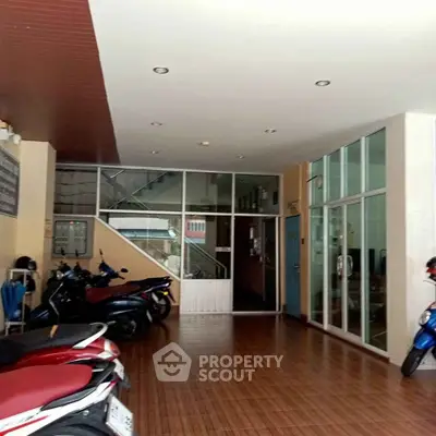 Spacious building entrance with motorbike parking and glass doors